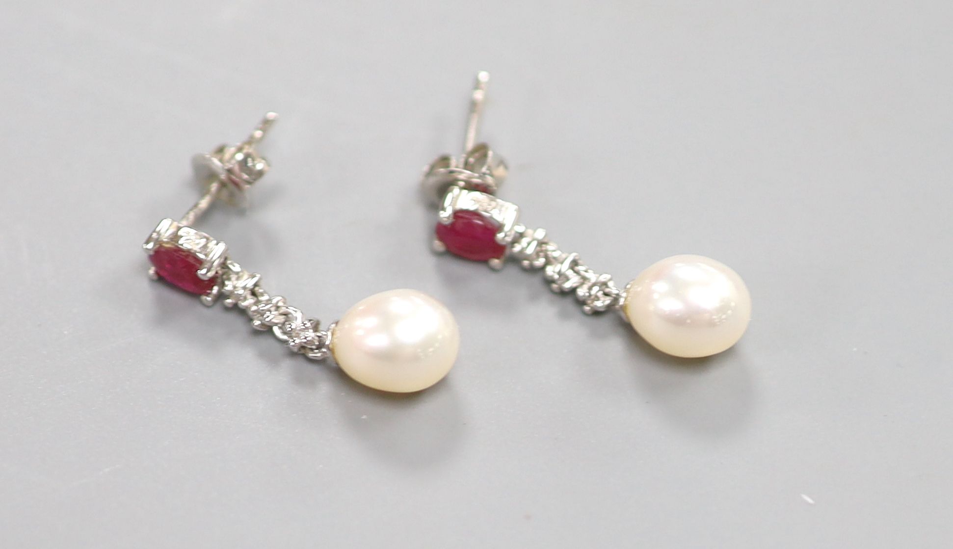 A modern pair of 750 white metal, ruby, diamond chip and cultured pearl set drop earrings, 22mm, gross 2.9 grams.